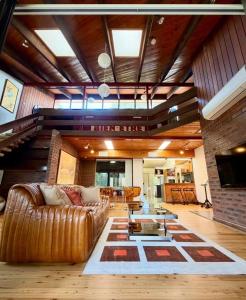 a living room with a couch and a table at Lake front, Mid-century house with sauna 2 in Budgewoi