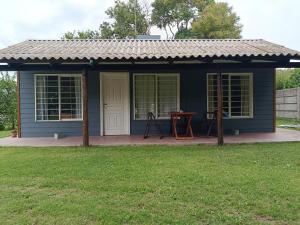 a blue house with a table in a yard at El Descanso in Las Flores