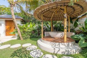 an umbrella sitting in the middle of a yard at Sicilia Villa - Ubud Pool Stay with Open-Air Bath & Gazebo in Ubud