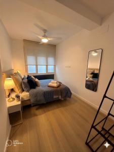 a bedroom with a bed and a desk and a mirror at Dulces Sueños Amistad in Valencia