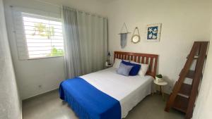 a bedroom with a bed with blue and white sheets at Recanto Mariel - 800m praia 2 quartos churrasqueira chuveirão rede Itaipuaçu in Maricá