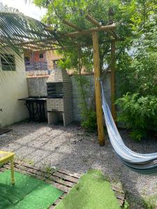 a hammock in a backyard with a grill at Recanto Mariel - 800m praia 2 quartos churrasqueira chuveirão rede Itaipuaçu in Maricá