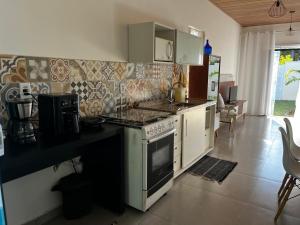 a kitchen with a stove and a counter top at Recanto Mariel - 800m praia 2 quartos churrasqueira chuveirão rede Itaipuaçu in Maricá