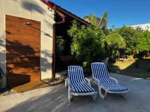 two blue and white chairs sitting next to a building at Recanto Mariel - 800m praia 2 quartos churrasqueira chuveirão rede Itaipuaçu in Maricá