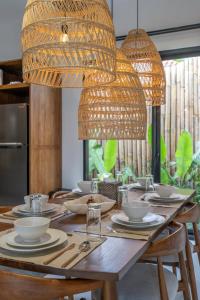 a dining room table with chairs and a large chandelier at Sicilia Villa - Ubud Pool Stay with Open-Air Bath & Gazebo in Ubud