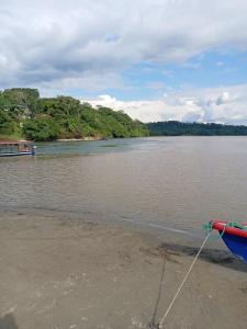 a boat sitting on the shore of a river at Chichicoland in Tena