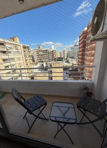 a balcony with two chairs and a view of a city at Monoambiente centrico con balcon y pileta in Rosario