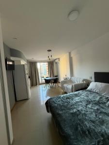 a hotel room with two beds and a table at Monoambiente centrico con balcon y pileta in Rosario