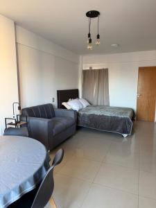 a living room with a couch and a bed at Monoambiente centrico con balcon y pileta in Rosario +4 photos