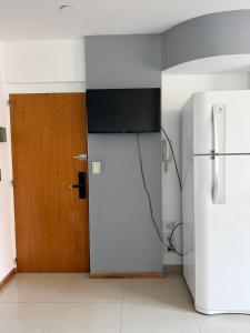 a kitchen with a refrigerator and a wooden door at Monoambiente centrico con balcon y pileta in Rosario