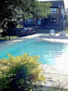 a pool of blue water in front of a house at La Porteña in Gualeguaychú +4 photos