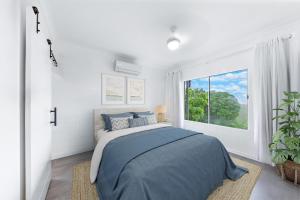 a bedroom with a bed and a large window at Ocean's Edge in Cannonvale +6 photos