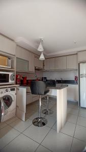 a kitchen with a table and a chair in it at Apê com vista pro Vale dos Vinhedos in Bento Gonçalves