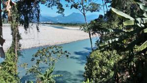 a river in the middle of a beach with trees at Hotel Puerto Selva in Villa Tunari +4 photos