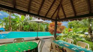 a patio with a table and chairs and a pool at Hotel Puerto Selva in Villa Tunari