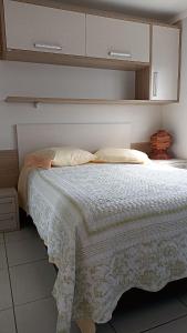 a bedroom with a bed with a white blanket at Apê com vista pro Vale dos Vinhedos in Bento Gonçalves
