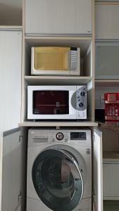 a microwave and a washing machine in a kitchen at Apê com vista pro Vale dos Vinhedos in Bento Gonçalves