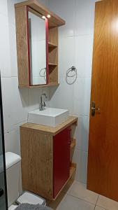 a bathroom with a sink and a mirror and a toilet at Apê com vista pro Vale dos Vinhedos in Bento Gonçalves +23 photos