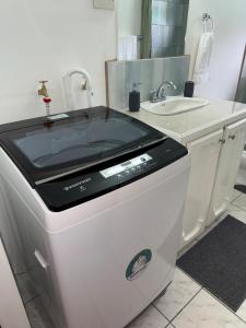 a bathroom with a sink and a washing machine at The Corinth House in Corinthe