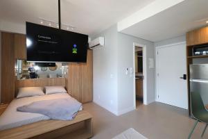 a bedroom with a bed with a flat screen tv on the wall at MOOD Modern Studio, Central Parque in Porto Alegre +11 photos