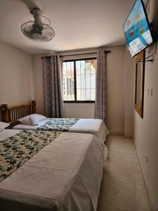 a bedroom with two beds and a window at Caribbean Airport Hotel in Cartagena de Indias