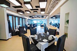 a dining room with tables and black chairs at Central Inn Hotel & Spa in Dhaka