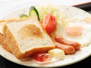 a plate of breakfast food with eggs sausage and toast at Tabist ONSEN MOTEL272 in Naka-shibetsu