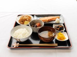 a tray of food with rice and bowls of food at Tabist ONSEN MOTEL272 in Naka-shibetsu