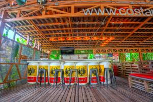 a restaurant with a bar with yellow and red at Arenal Backpackers Resort in Fortuna +109 photos