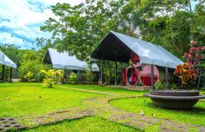 a garden with a fountain in the middle of a yard at Arenal Backpackers Resort in Fortuna