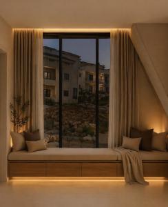 a window seat in a room with a large window at Casa del Rosa in Kafr ‘Ubaydā