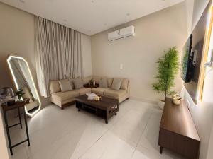 a living room with a couch and a table at Al Hamra Modern Suite, Khobar in Al Khobar