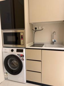 a kitchen with a microwave and a washing machine at Al Hamra Modern Suite, Khobar in Al Khobar