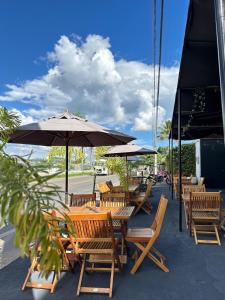 a group of wooden tables and chairs with umbrellas at Hotel Santorini in Trindade