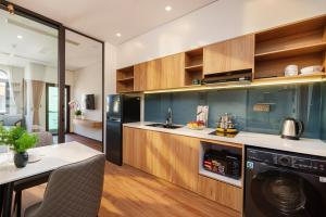 a kitchen with wooden cabinets and a washer and dryer at Cossy Home by BRIO in Danang