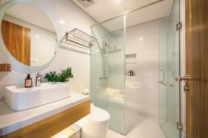 a bathroom with a sink and a glass shower at Cossy Home by BRIO in Danang
