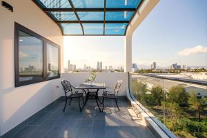 a balcony with a table and chairs and a view of the city at Cossy Home by BRIO in Danang