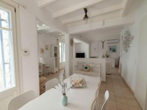 a white living room with a white table and chairs at Mykonos Villa for 8 with Pool in Mikonos