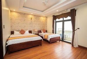 a bedroom with two beds and a large window at Ks sơn trang 1 in Sầm Sơn