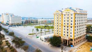 a large yellow building in a city with a street at Ks sơn trang 1 in Sầm Sơn