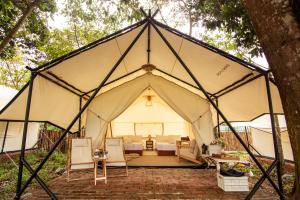 a large tent with chairs and a bed in it at Suka Camping - Bentong in Bentong