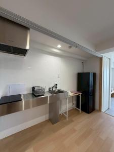 a kitchen with a sink and a refrigerator at Bliss長浜 in Oita