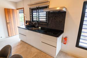 a kitchen with white cabinets and a black counter top at Lobby Apartments in Paramaribo
