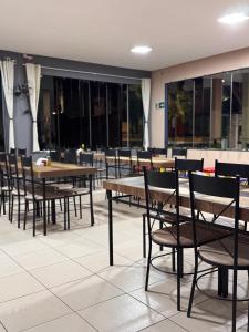 a dining room with tables and chairs and windows at Hotel Volpi Salinas in Salinas
