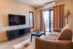 a living room with a couch and a flat screen tv at Lobby Apartments in Paramaribo