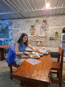 a woman sitting at a wooden table eating food at Iza home stay in Senaru +112 photos