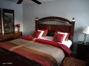 a bedroom with a large bed with red pillows at Home Away From Home in Moncton
