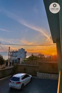 a white car parked in a parking lot with a sunset at Oscar’s Apartments Drymades in Dhërmi +20 photos