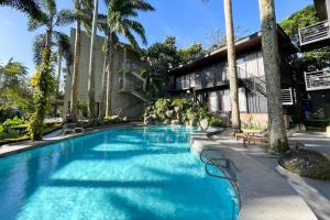 a swimming pool in front of a building with palm trees at Novella Tagaytay in Tagaytay +25 photos