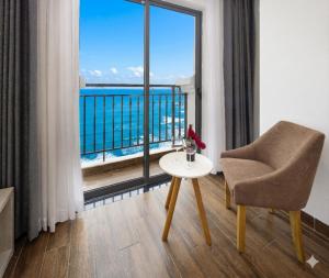 a room with a chair and a table and a window at Hon Chong Retreat Hotel Nha Trang in Nha Trang